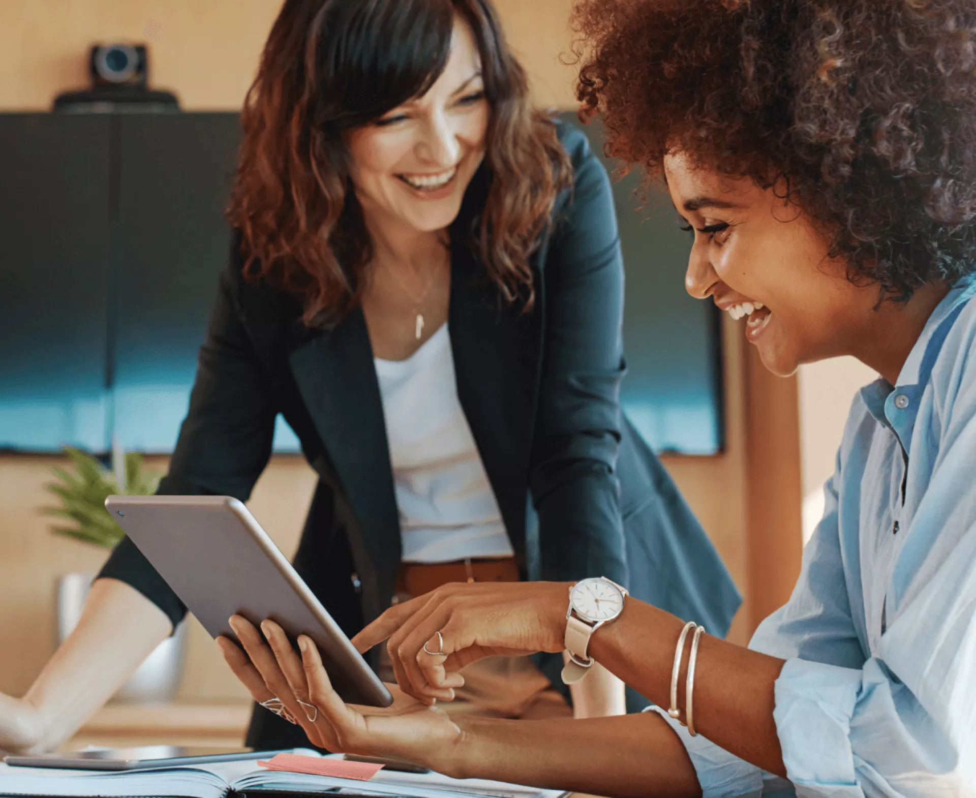 Twee vrouwen werken samen en bekijken een tablet.