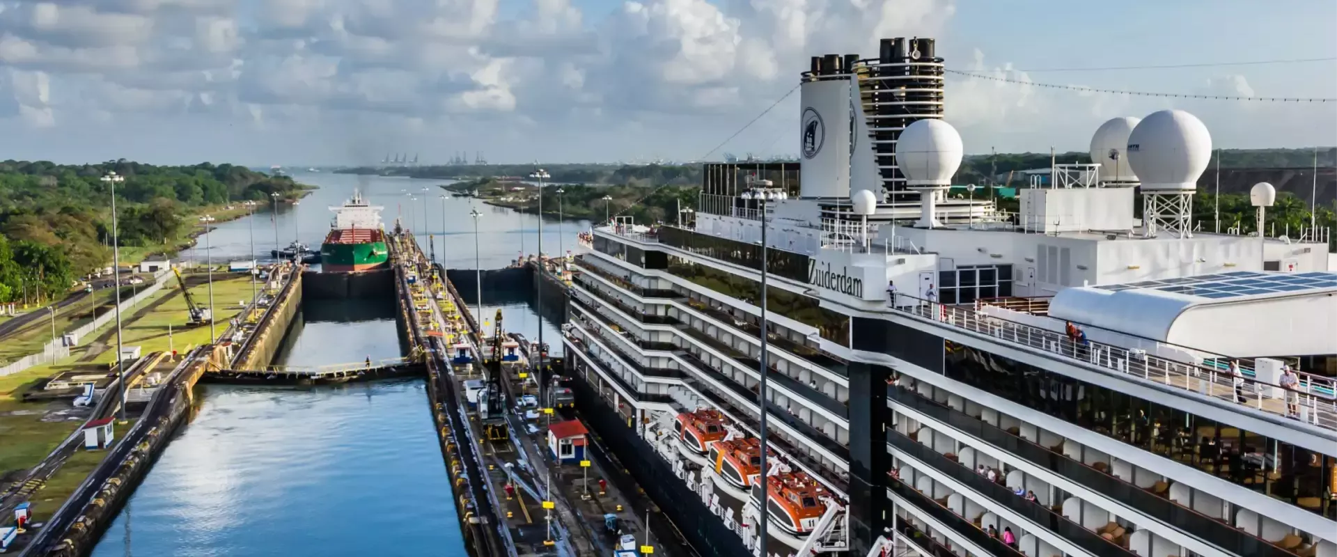 Een cruiseschip en een vrachtschip passeren de sluizen van het Panamakanaal.