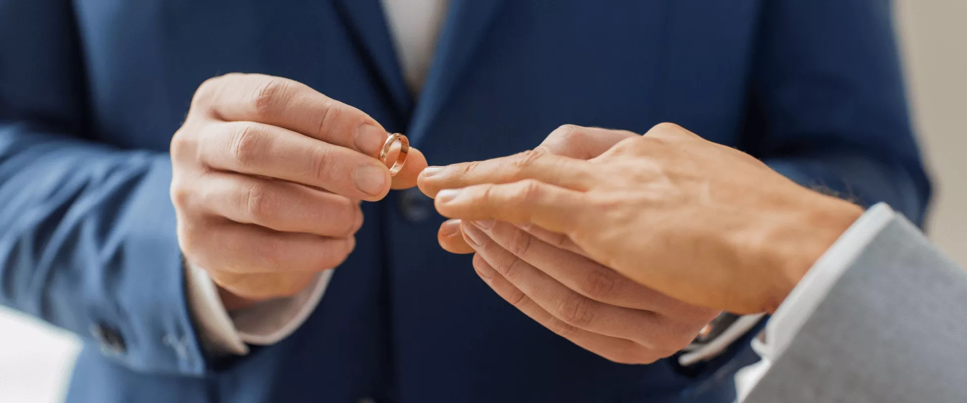 Een man doet een ring om bij een andere man tijdens een huwelijksceremonie.