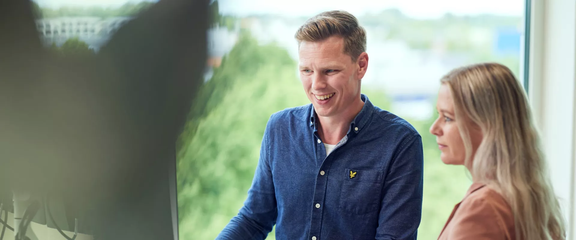 Twee mensen werken samen achter een computer.