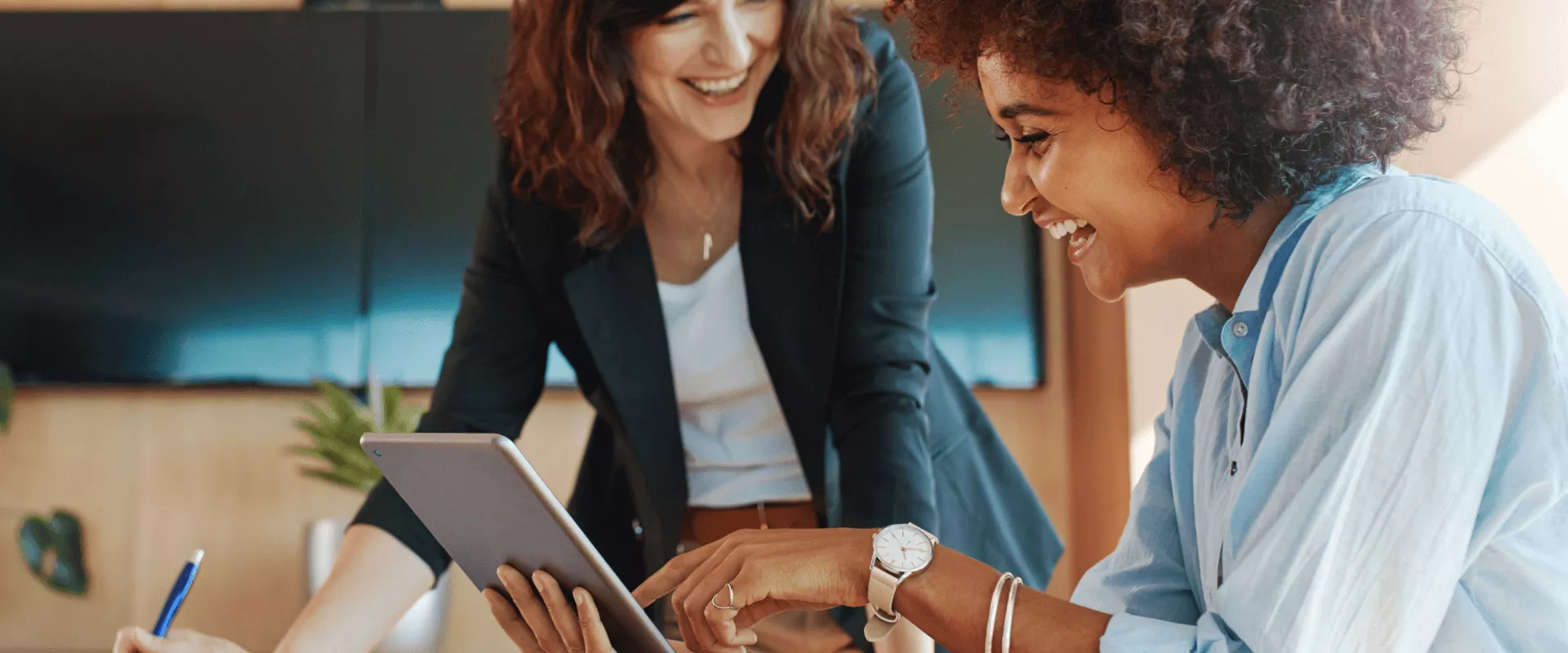 Twee vrouwen werken samen en bekijken een tablet.