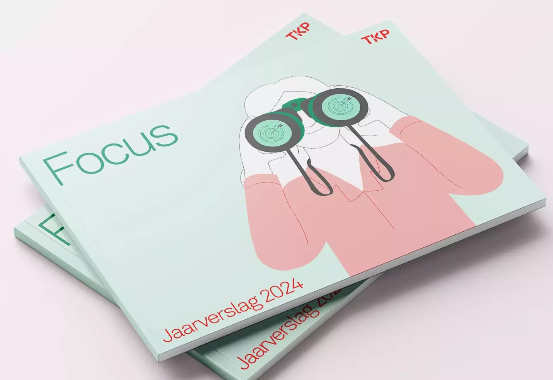 Een stapel brochures met een illustratie van een persoon met een verrekijker en de tekst "Focus" en "Jaarverslag 2024".