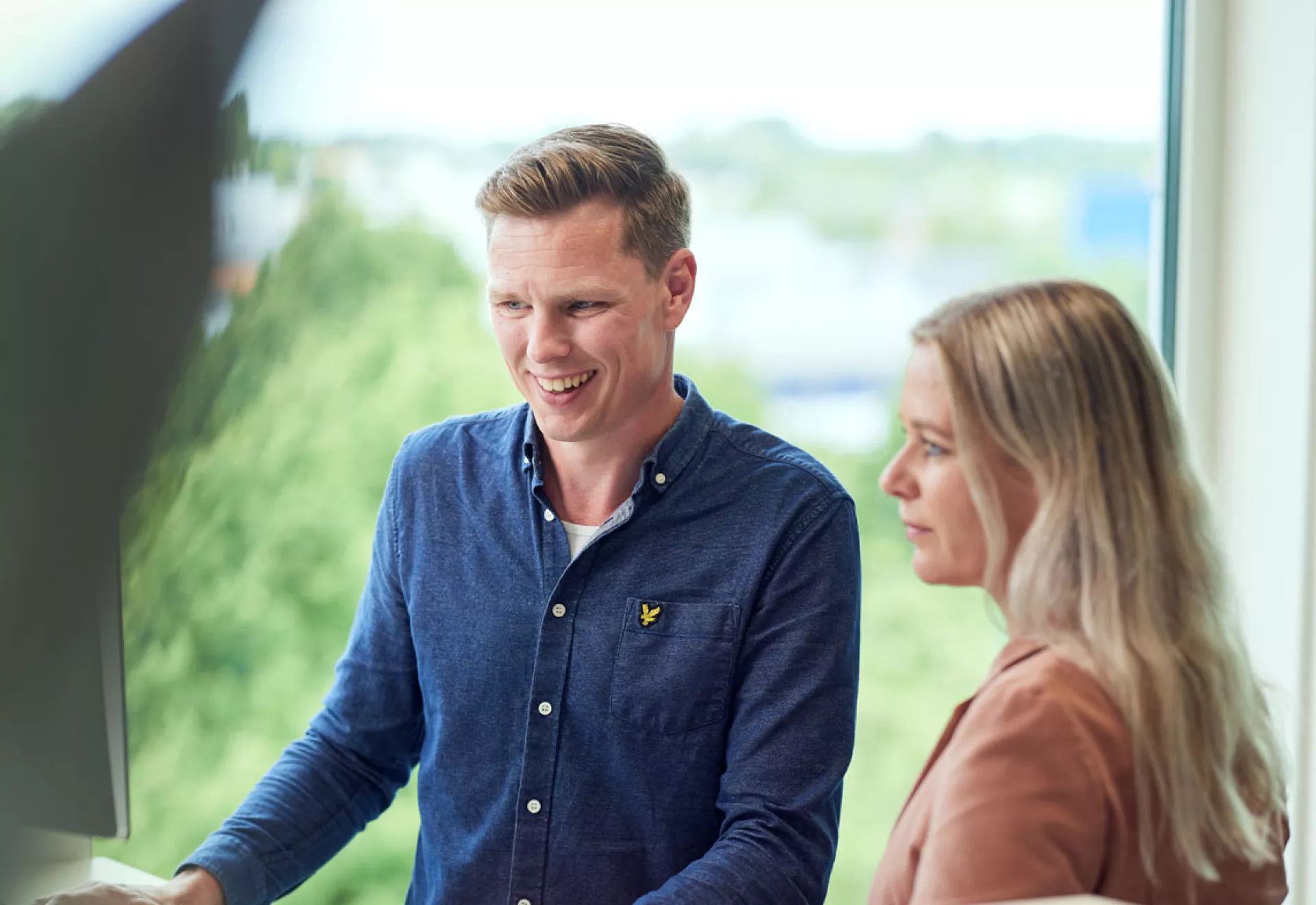Twee mensen werken samen achter een computer.