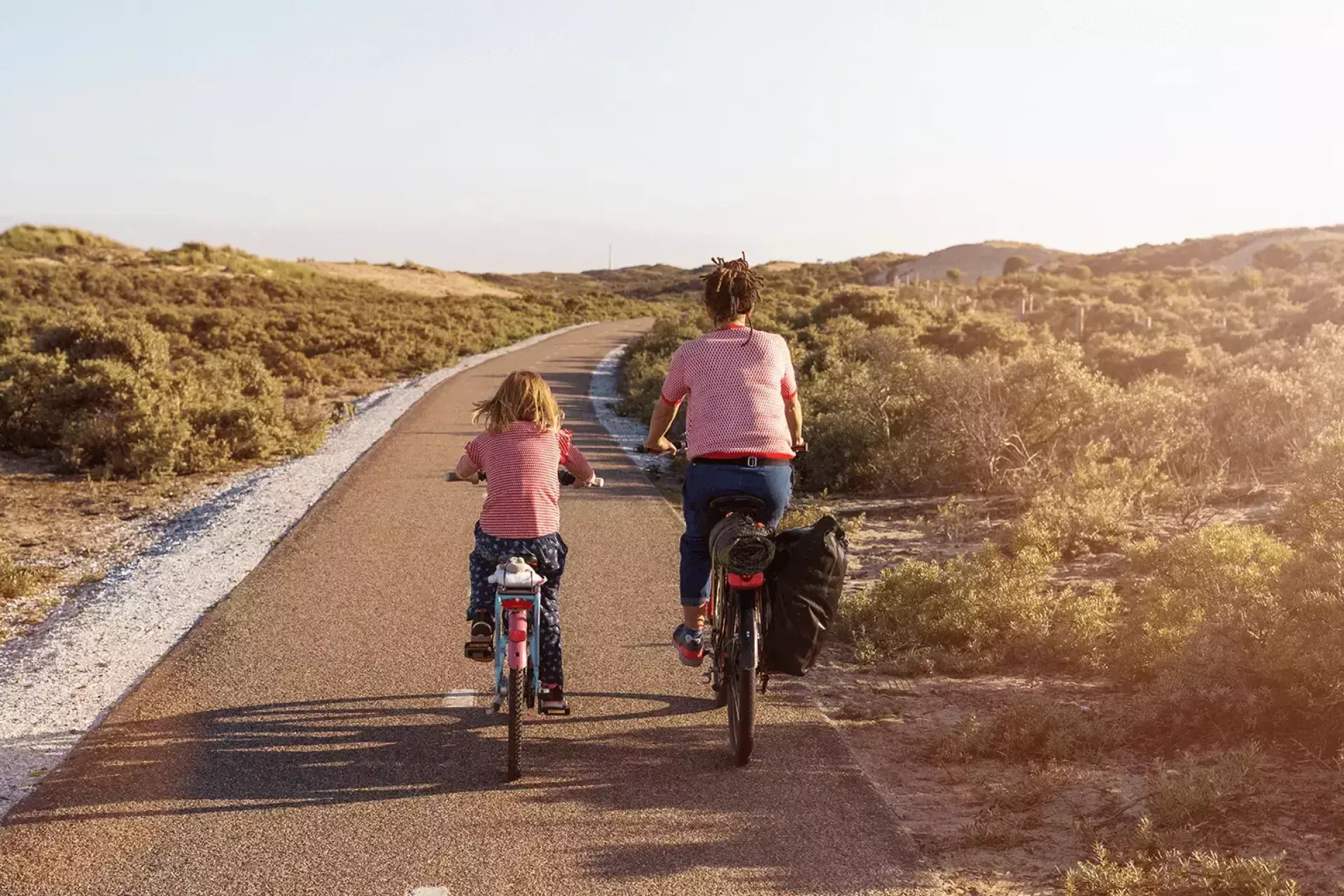 Twee mensen fietsen samen over een pad in een natuurlijke omgeving.