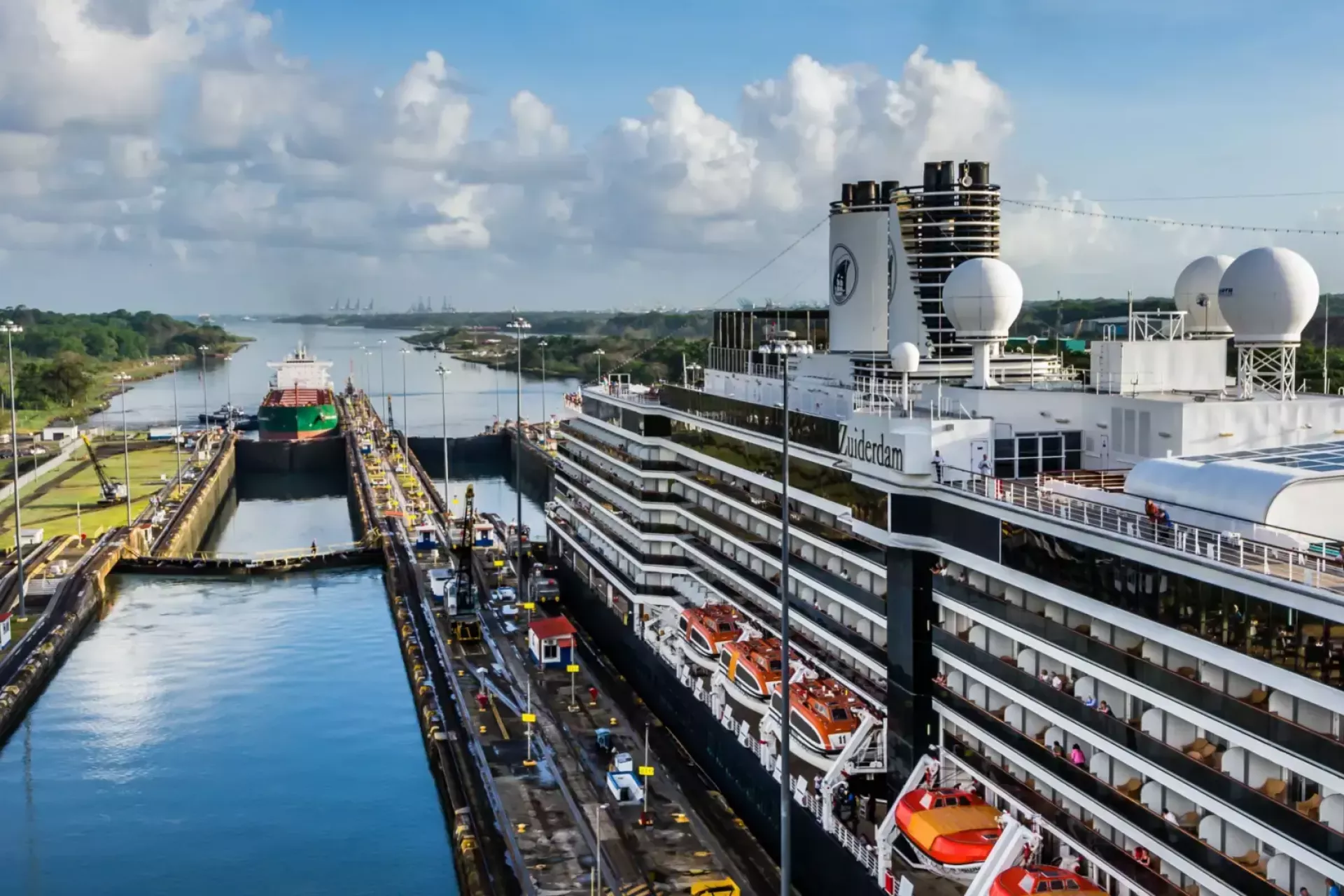 Een cruiseschip en een vrachtschip passeren de sluizen van het Panamakanaal.