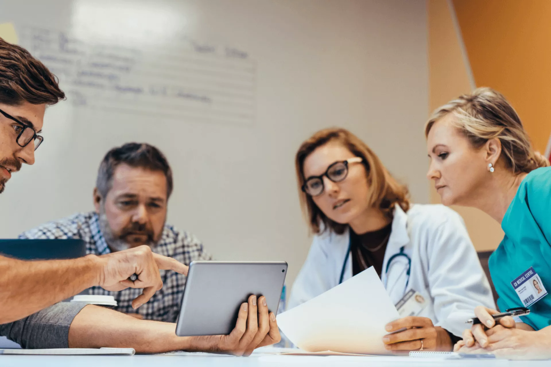 Een medisch team bespreekt informatie op een tablet.