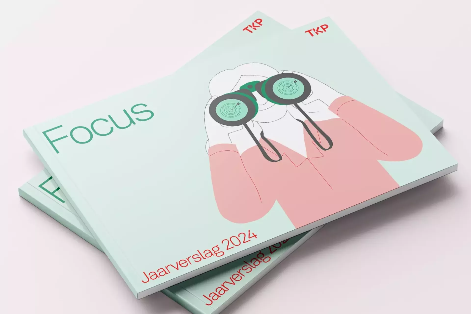 Een stapel brochures met een illustratie van een persoon met een verrekijker en de tekst "Focus" en "Jaarverslag 2024".