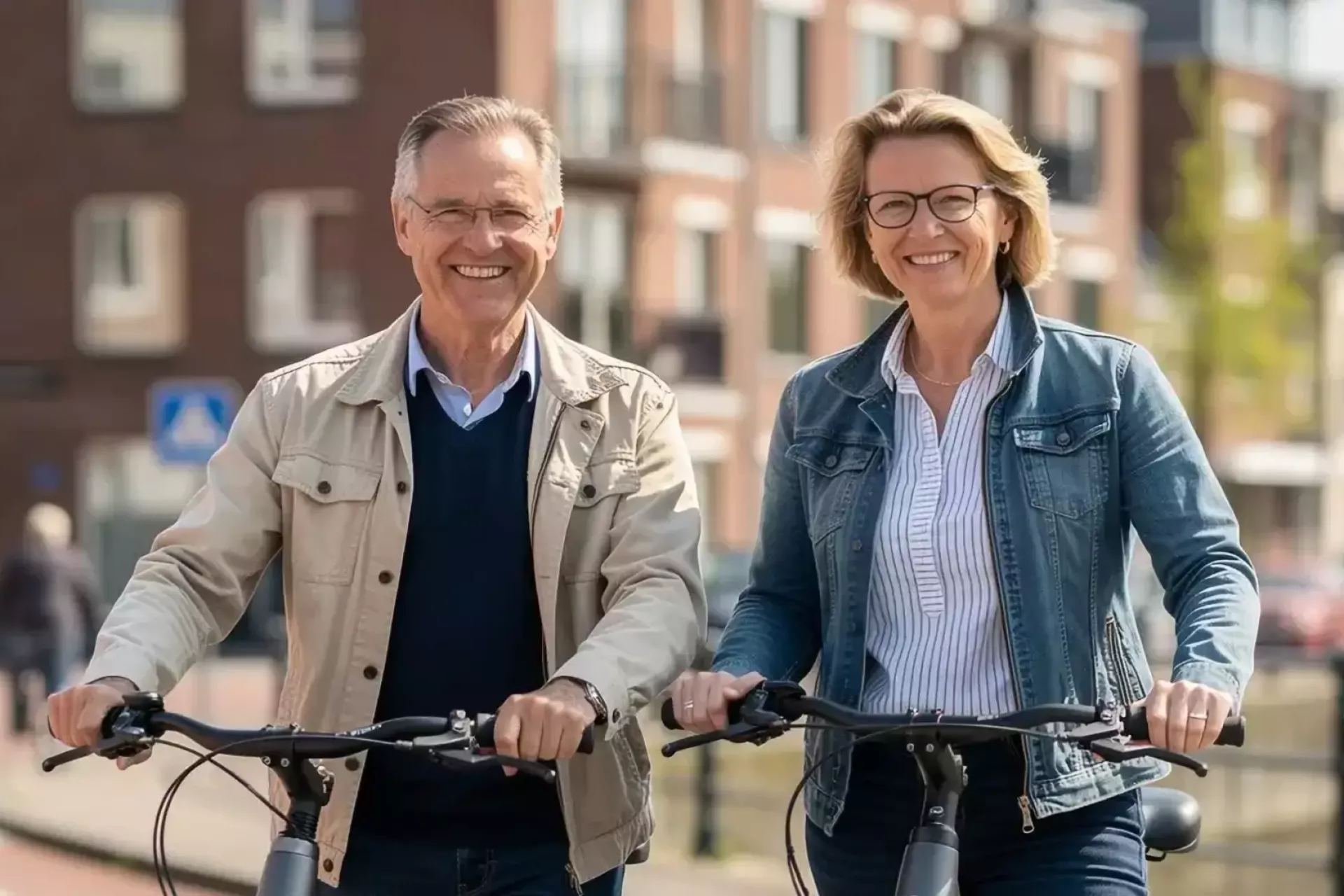 Een glimlachend stel fietst samen door een stad.