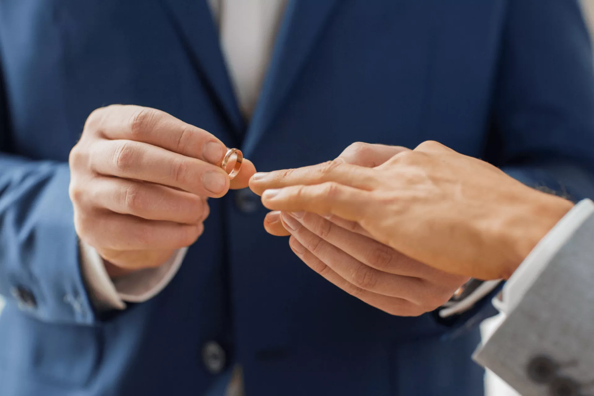 Een man doet een ring om bij een andere man tijdens een huwelijksceremonie.