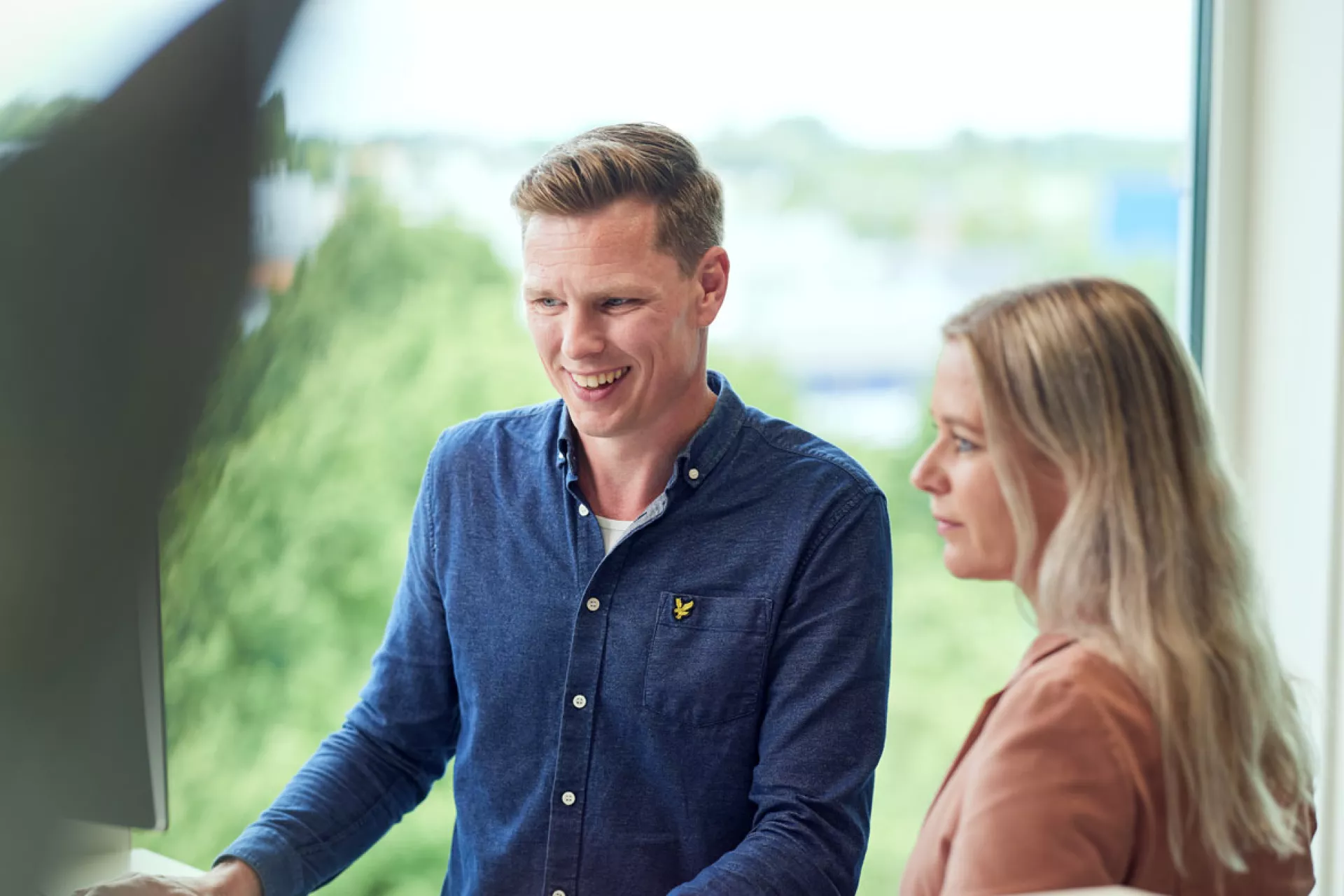 Twee mensen werken samen achter een computer.
