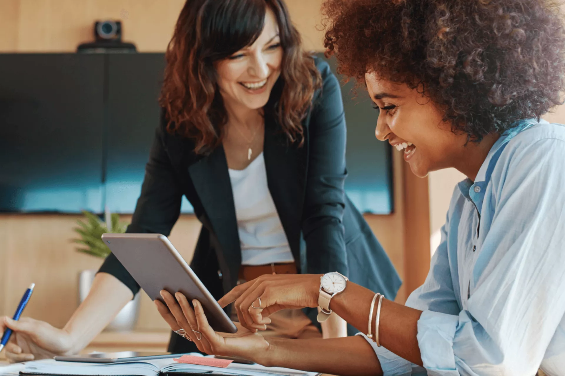 Twee vrouwen werken samen en bekijken een tablet.